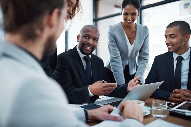 Shot of a group of businesspeople discussing something on a laptop